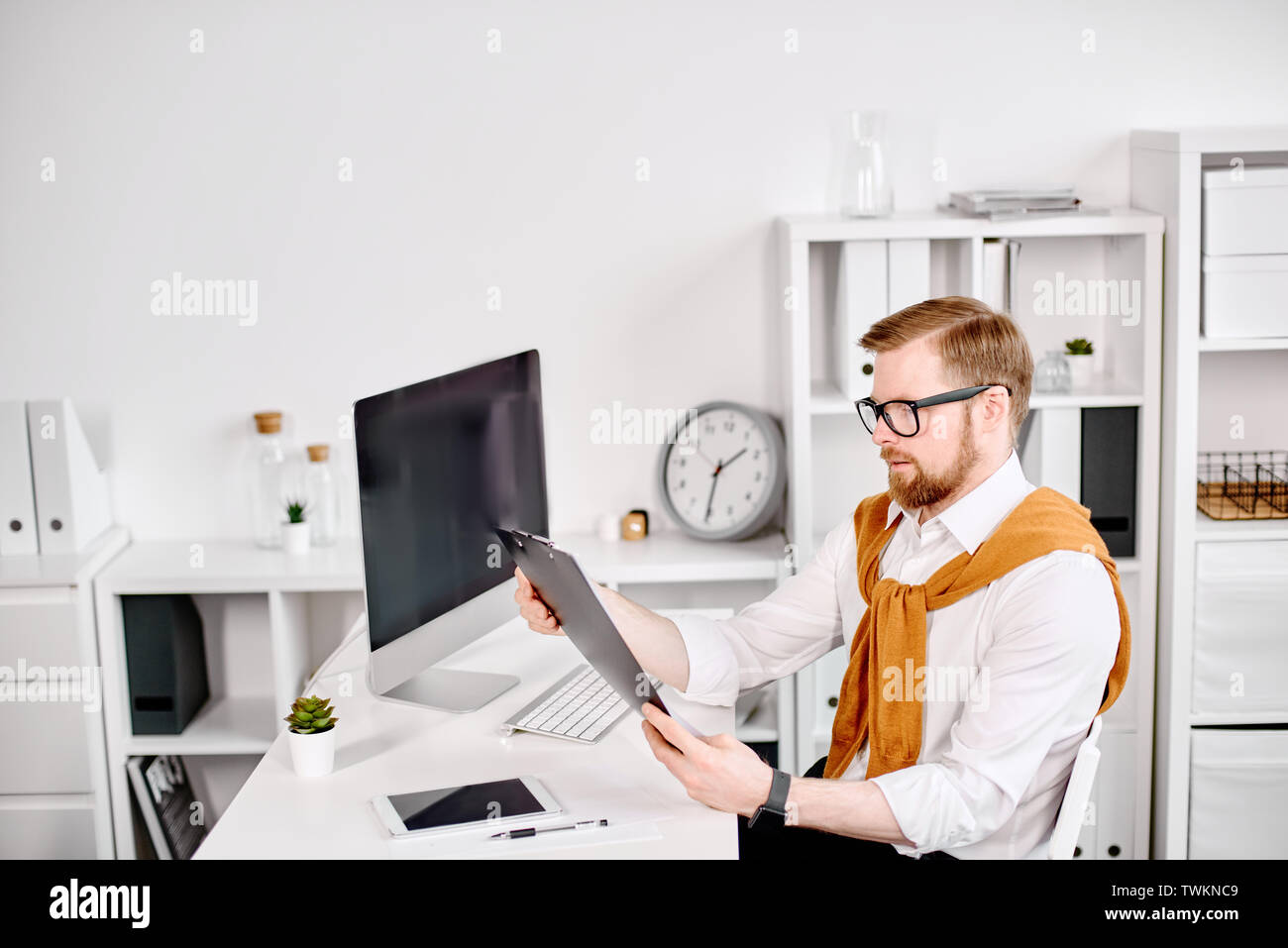 Età media imprenditore lavora con dokuments al computer in ufficio Foto Stock