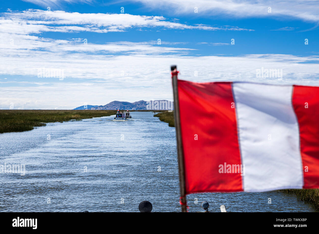 Il bianco e il rosso peruviana bandiera nazionale a volare su una barca sul lago Titicaca, Perù, Sud America Foto Stock