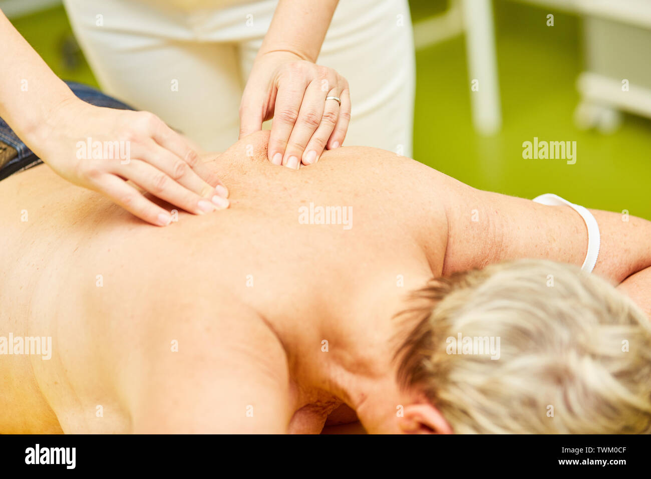 Il paziente riceve il massaggio alla schiena durante la fisioterapia da massaggiatore o chiropratico Foto Stock