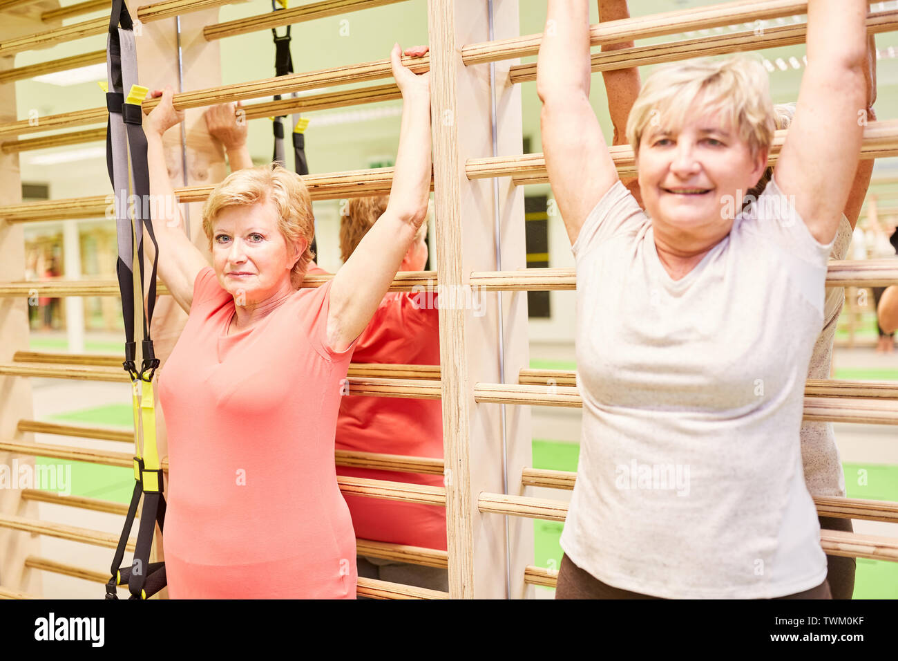 Le donne anziane facendo ginnastica sulla parete barre in senior sport in esercizi per la schiena Foto Stock