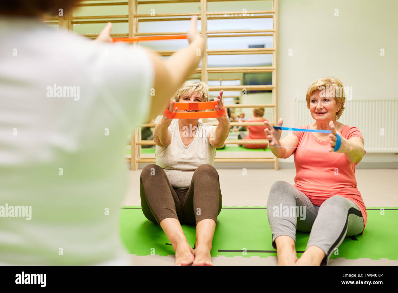 Seniors stazione di forza con il con elastici Theraband nel rehab di fisioterapia con la guida Foto Stock