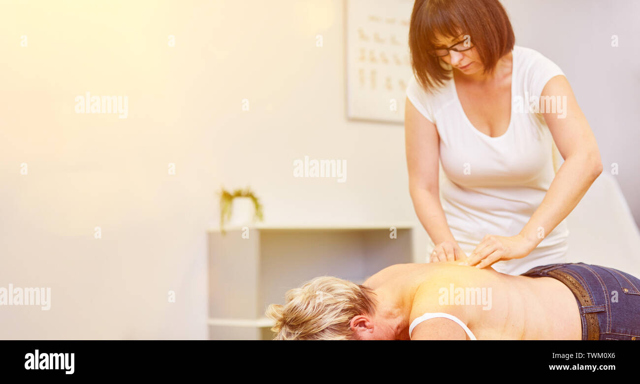 Vecchia donna prendendo il massaggio come trattamento per il mal di schiena in fisioterapia o chiropratica Foto Stock