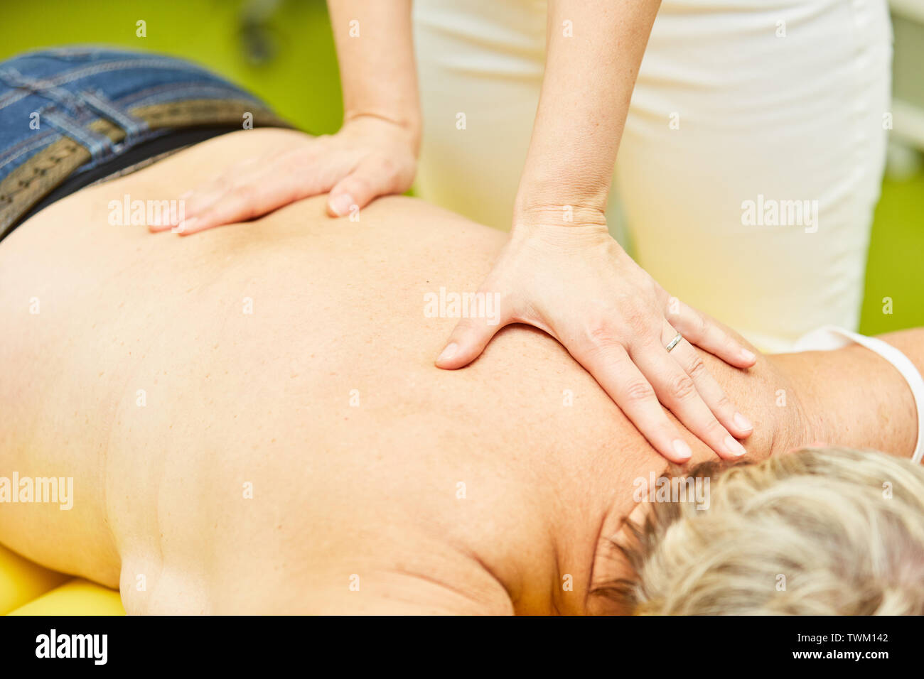 Senior come un paziente riceve un massaggio alla schiena da un chiropratico o massaggiatore Foto Stock