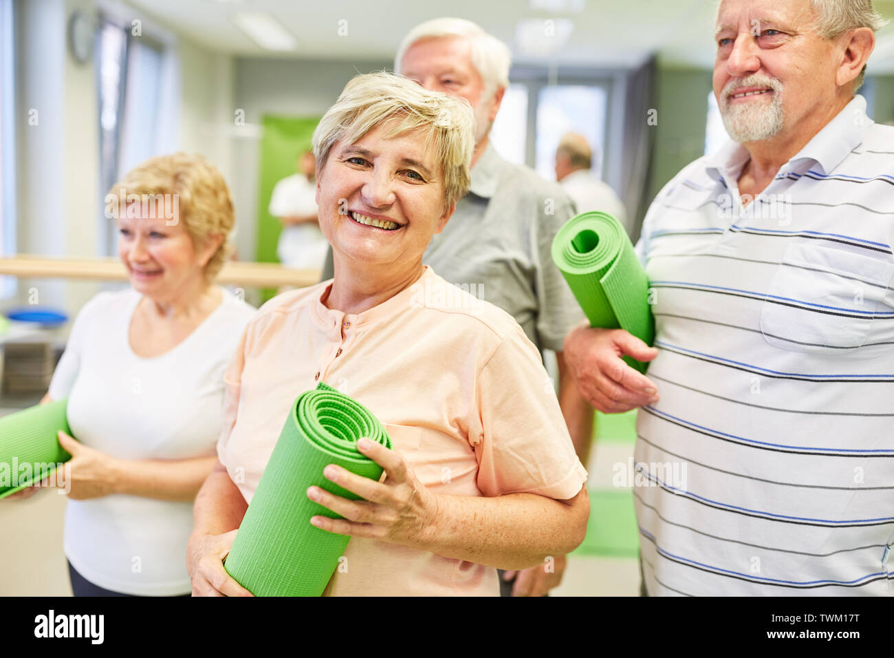 Felice donna senior con amici insieme in una classe di ginnastica in palestra Foto Stock