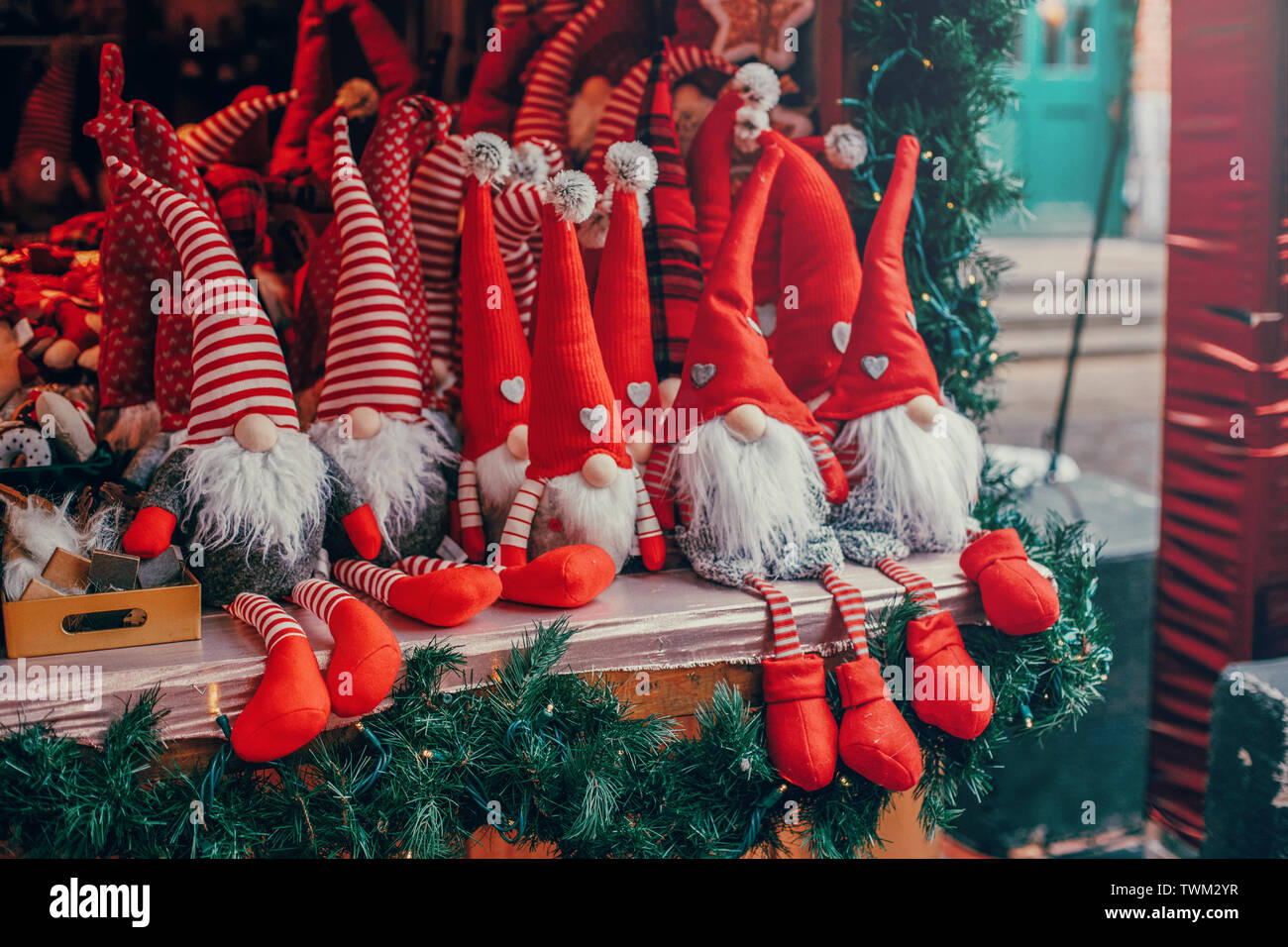 Colorato di rosso giocattoli nani gli gnomi di cappucci rossi cappelli  seduti sul contatore ad una festa tradizionale mercato di Natale  all'esterno. Popolari Attrazioni invernali Foto stock - Alamy