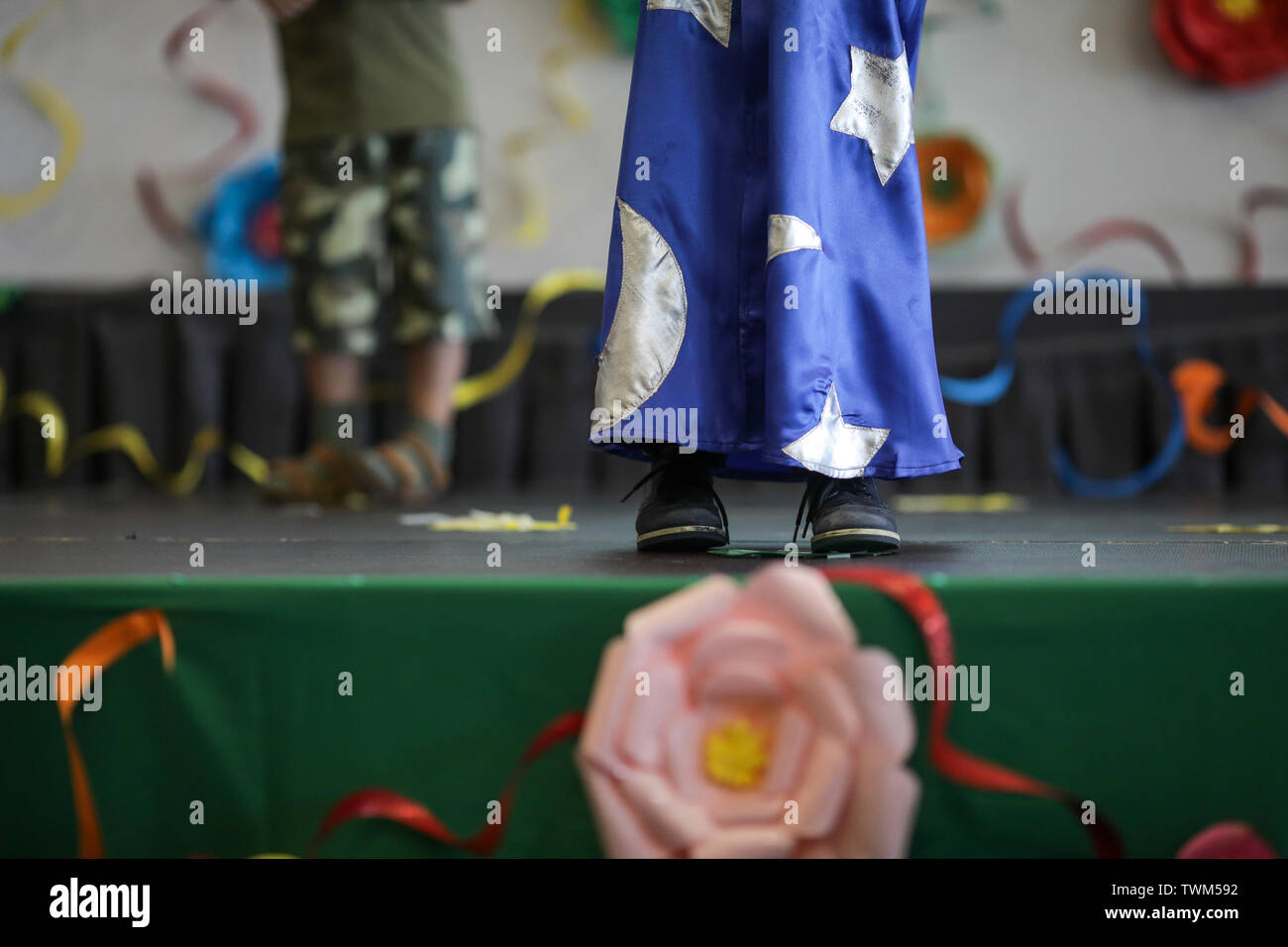 Dettagli con il mago vestito di un piccolo ragazzo ad esibirsi sul palco durante un kindergarten prom celebrazione. Foto Stock