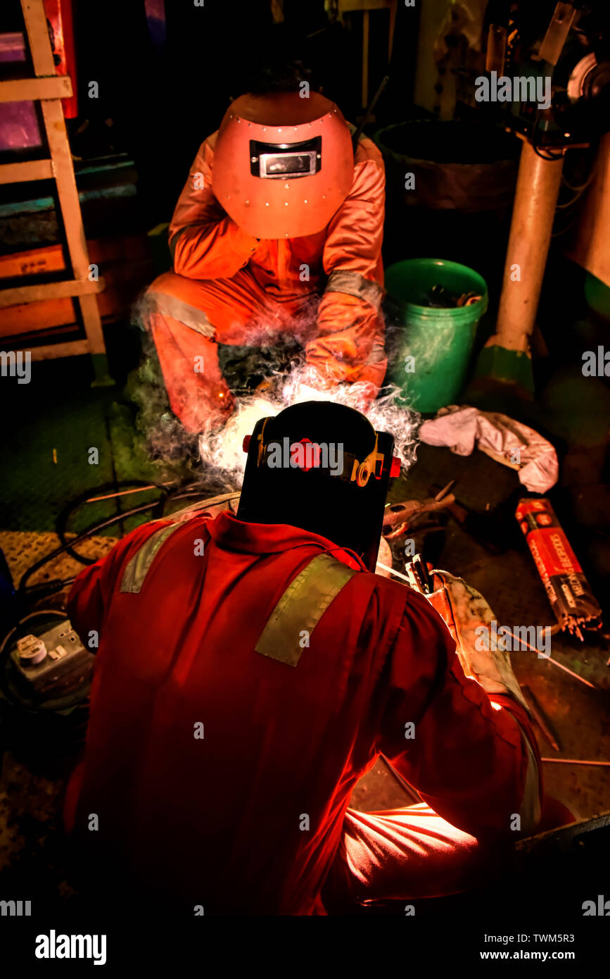 tubo di saldatura dell'equipaggio marino fuoriuscito nell'officina del vano motore Foto Stock
