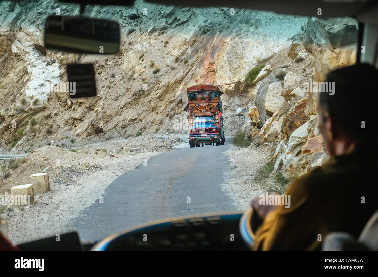 Un bel locale pakistano decorata carrello acceso sulla pericolosa strada di montagna nel Karakoram Highway, Pakistan. Vista dal parabrezza. Foto Stock