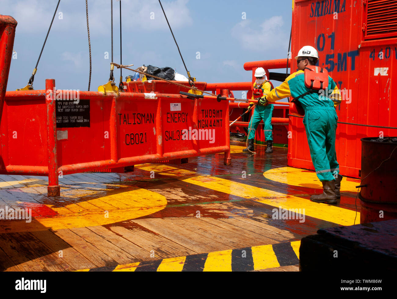 Equipaggio di marino di manipolazione e organizzare il carico sul ponte utilizzando lo strumento speciale per precauzione di sicurezza Foto Stock