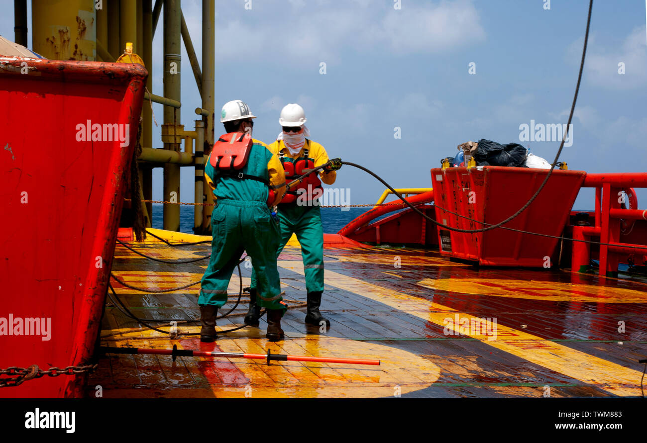 Equipaggio di marino di manipolazione e organizzare il carico sul ponte utilizzando lo strumento speciale per precauzione di sicurezza Foto Stock