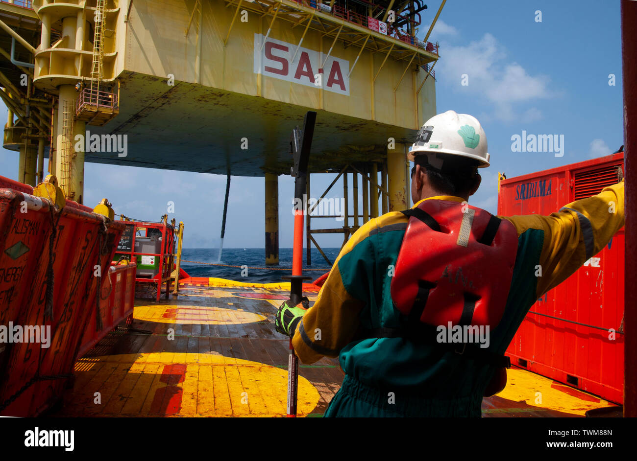 Equipaggio di marino di manipolazione e organizzare il carico sul ponte utilizzando lo strumento speciale per precauzione di sicurezza Foto Stock