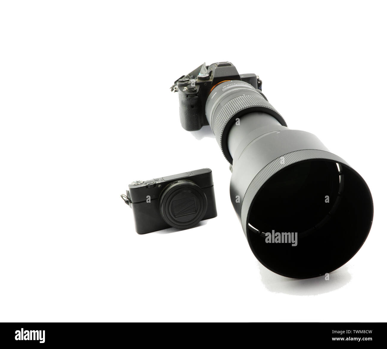 Mirrorless blac fotocamera di sistema con telezoom ultratele 150mm a 600mm e piccola fotocamera compatta a confronto Foto Stock