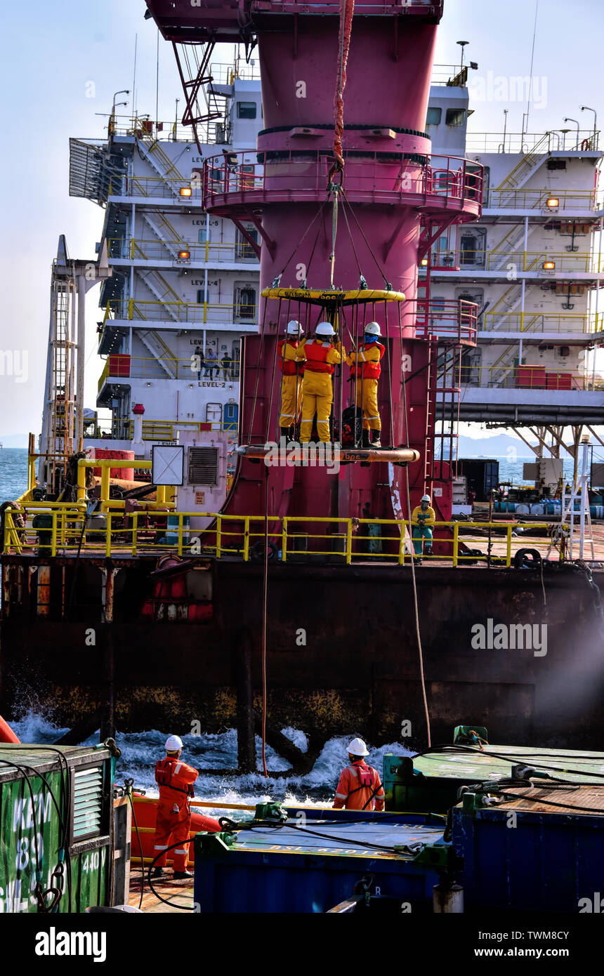 Lavoratore offshore personel trasferimento dall'alloggio chiatta per supporto offshore Nave mediante gru Foto Stock