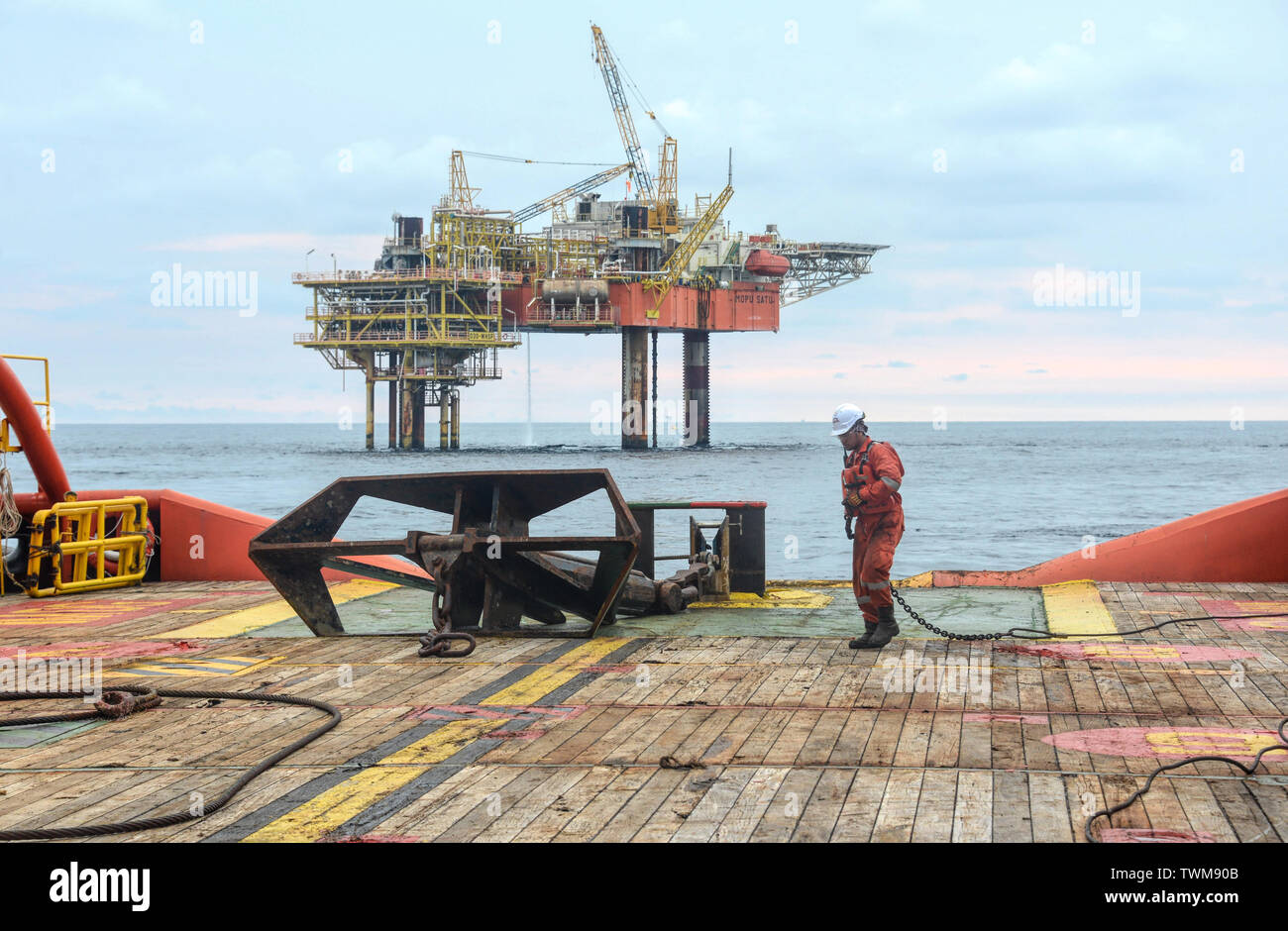 Equipaggio marino preparazione ancora sulla piattaforma prima di installare il dispositivo di ancoraggio a mare Foto Stock