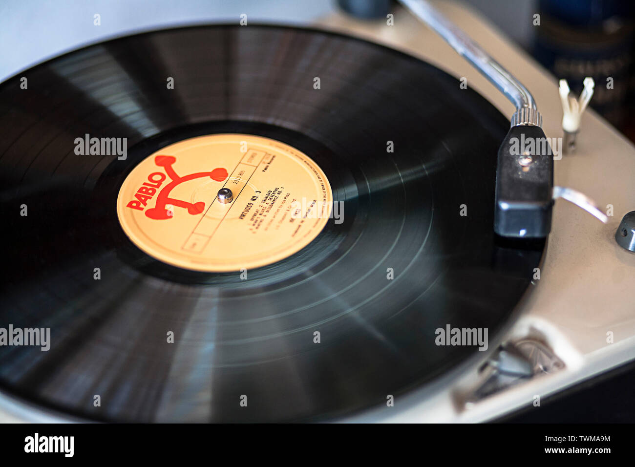 Primo piano foto di un classico album musicale jazzy Pablo che suona su un giradischi, un braccio tonico e una testa-shell. Leggera sfocatura del movimento sul vinile stesso. Foto Stock