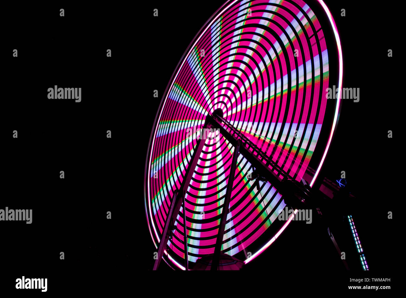 Rosa ruota panoramica Ferris al fair notte con una lunga esposizione. Foto Stock