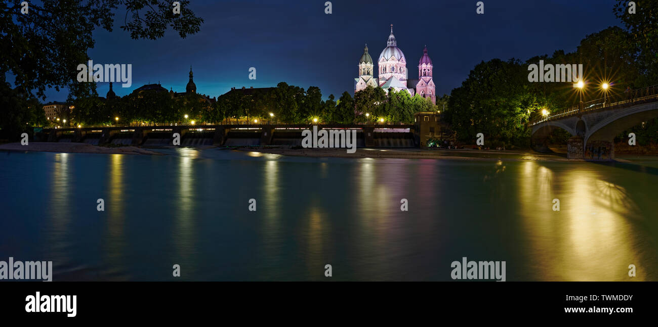 Una lunga esposizione ampio angolo riprese notturne dell'Isar Wehrsteg con un ponte sulla destra e Sankt Lukas chiesa in background. Foto Stock