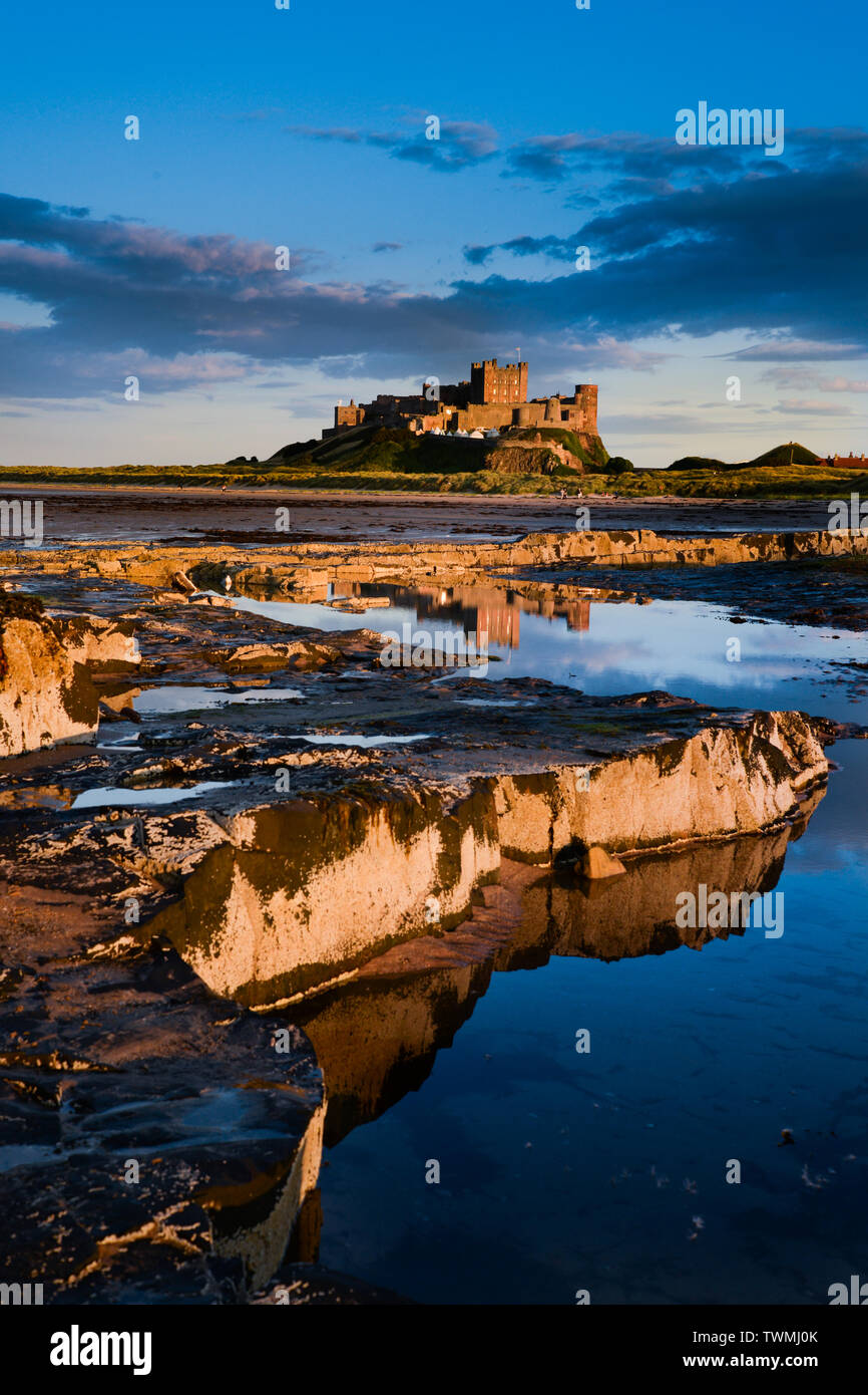 Il castello di Bamburgh e la spiaggia sulla costa di Northumberland Foto Stock