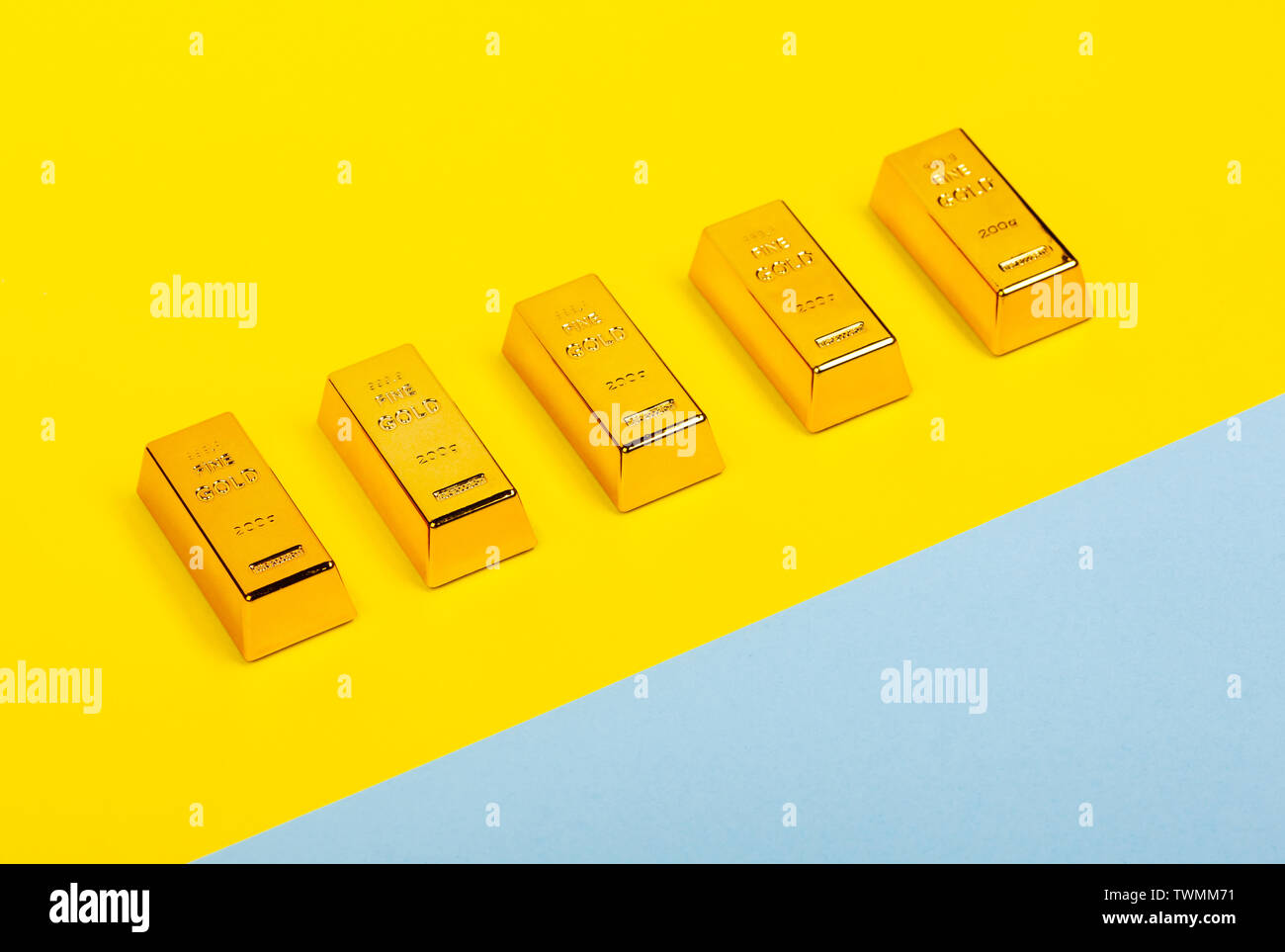 Barre di Gold bullion su giallo e blu chiaro dello sfondo. Piano finanziario. Foto Stock