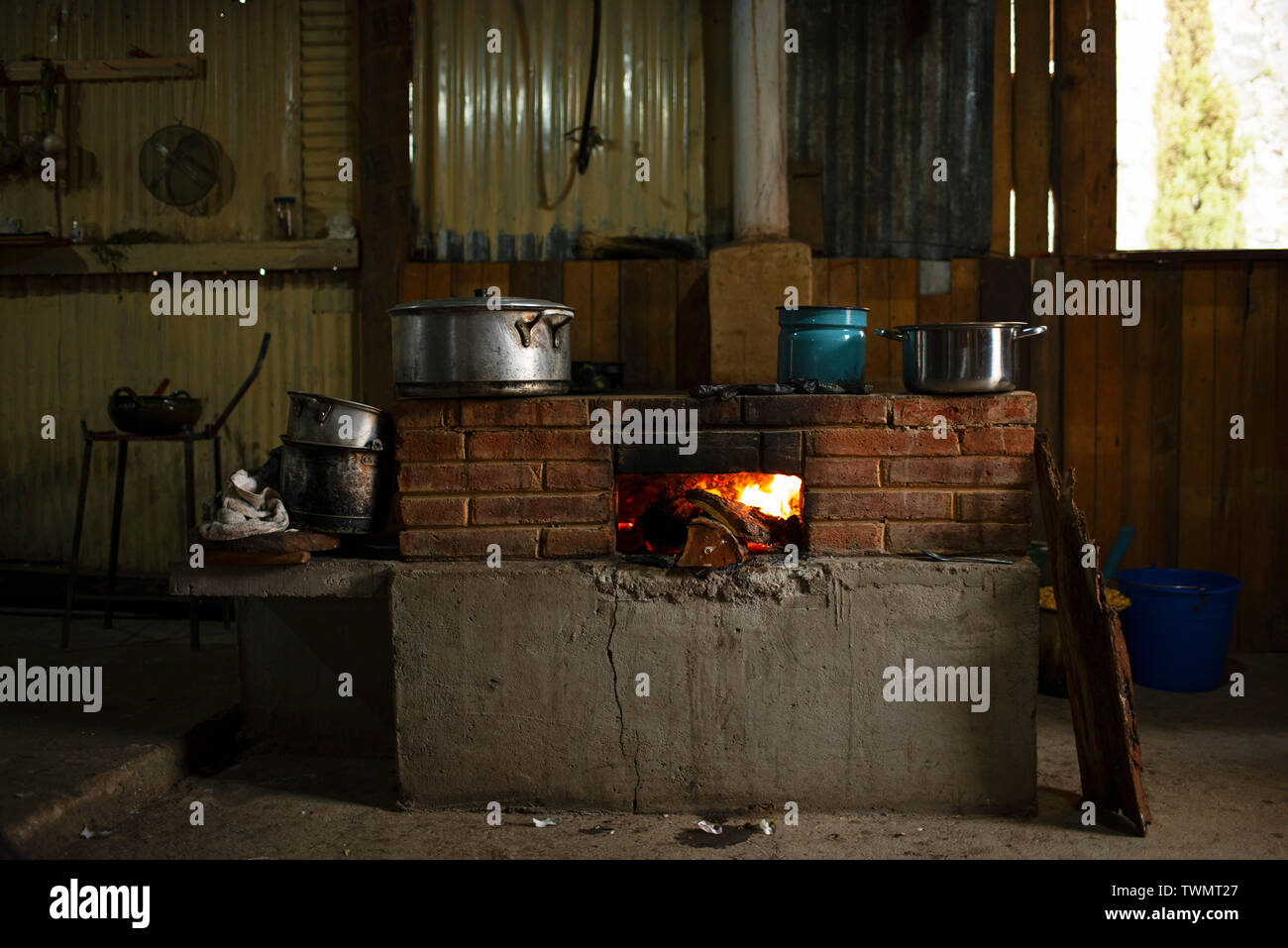 Cucina interna una buca per il fuoco in nativo di una donna di casa. San José del Pacífico, Oaxaca, Messico. Maggio 2019 Foto Stock