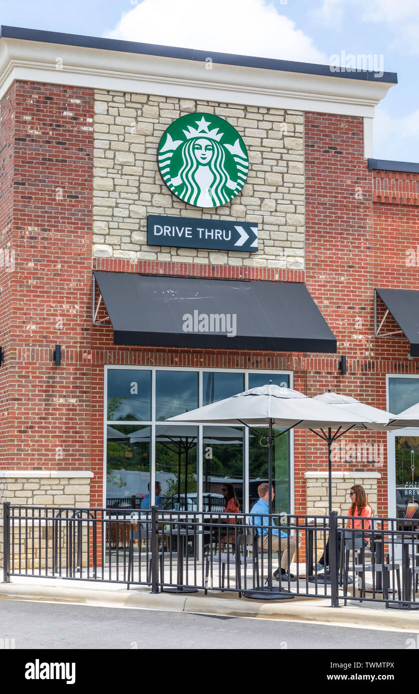 STATESVILLE, NC, USA di giugno 19, 2019: un locale Starbucks coffehouse, con un paio di posti a sedere fuori in una giornata di sole. Foto Stock