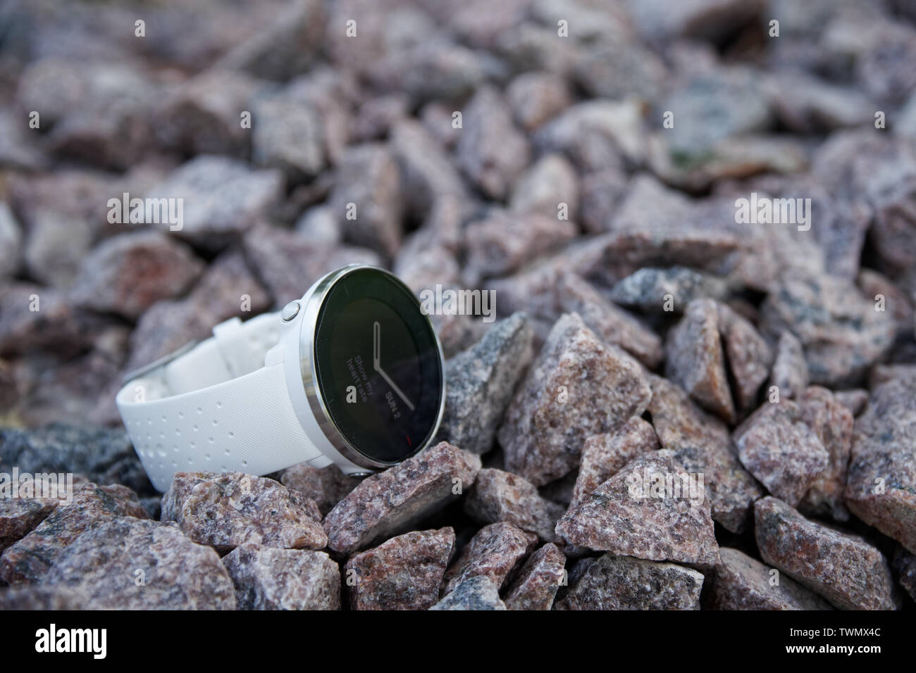 Orologio sportivo per il triathlon sulla ghiaia in granito. Orologio intelligente per tenere traccia delle attività quotidiane e la forza di formazione Foto Stock