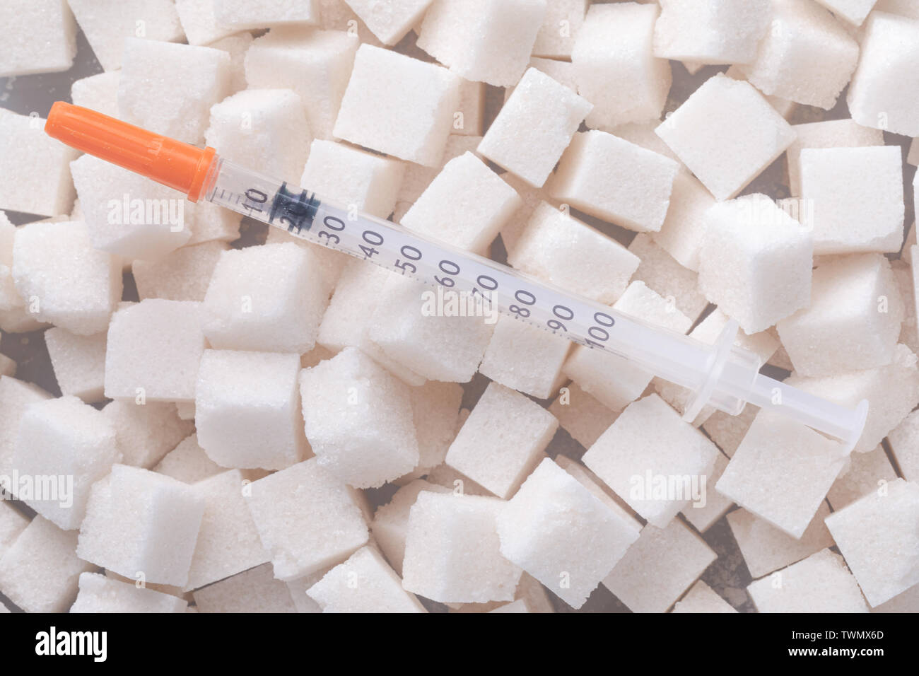 Siringa da insulina su cubetti di zucchero sfondo, diabete concetto di trattamento Foto Stock
