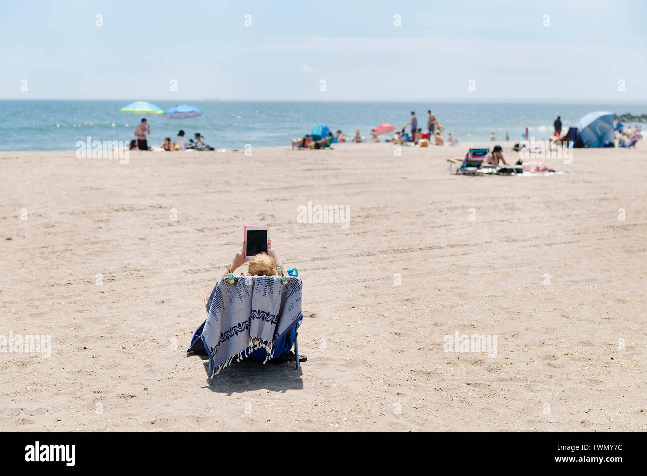 Una donna la lettura sulla spiaggia all'Rockaways. Foto Stock