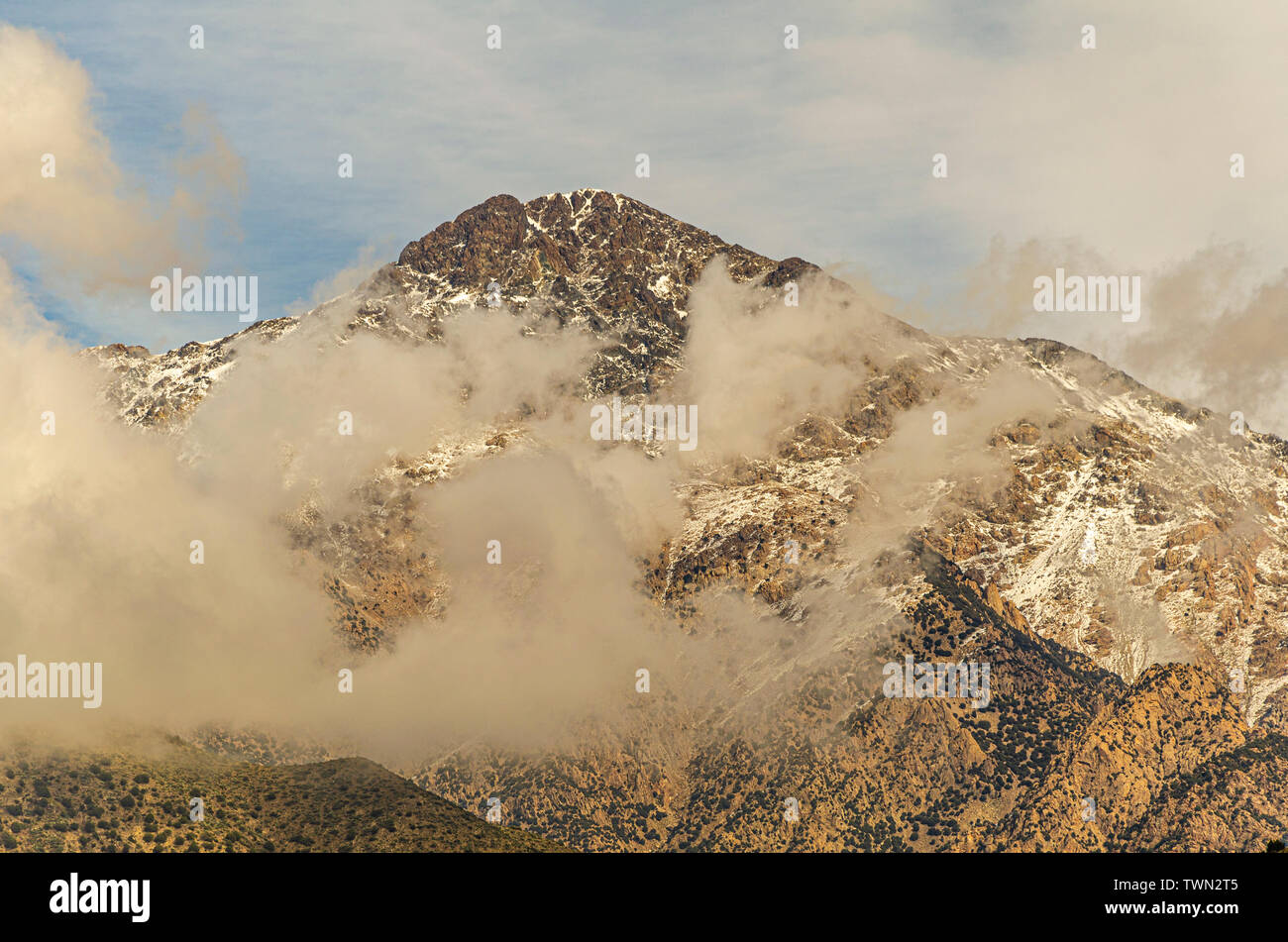 Montagna innevata top tra le nuvole nel montagne nelle vicinanze di Marrakesh.. Il Marocco Foto Stock