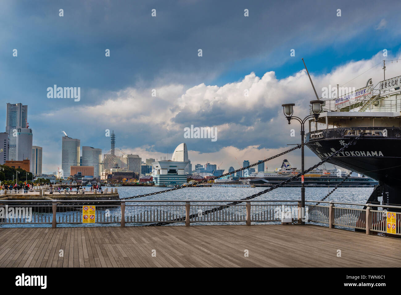Vista di Minato Mirai skyline e la famosa Hikawa Maru nave su una giornata noiosa, dalla città di Yokohama Port pier Foto Stock