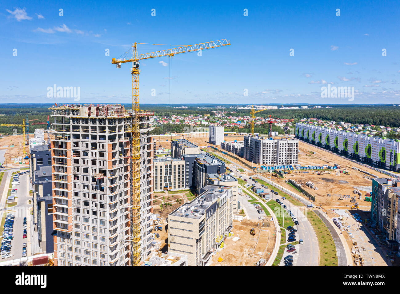 Sito in costruzione con highrise building e gru sul cielo azzurro sfondo. nuova zona residenziale. Vista aerea Foto Stock