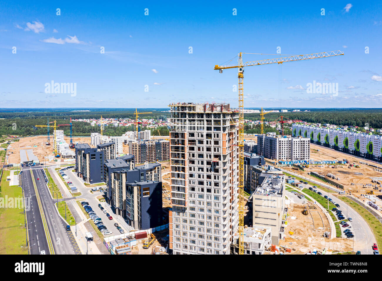 Lo sviluppo della nuova area residenziale. gru e la costruzione dell'edificio sito contro il cielo blu. vista aerea Foto Stock