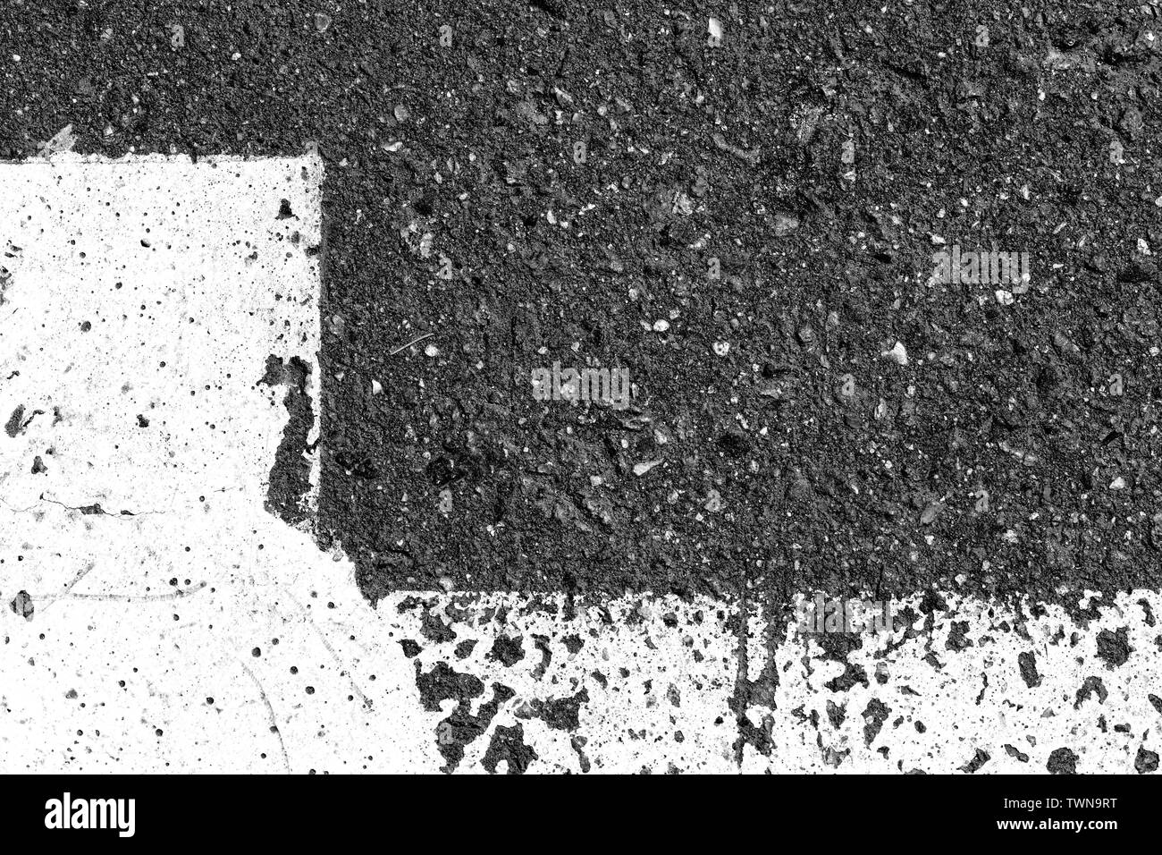 Superficie di asfalto con la vecchia vernice su di esso vicino. Sfondo astratti in bianco e nero Foto Stock
