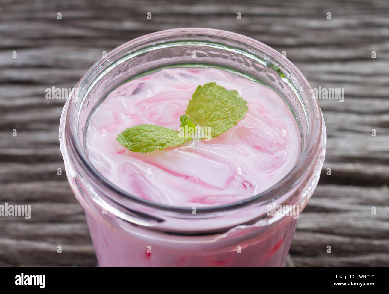 Rosa latte freddo o Bevande Bevande fredde e menta piperita vista normale. Rosa bevande fredde e di ghiaccio sul tavolo di legno per bere Foto Stock