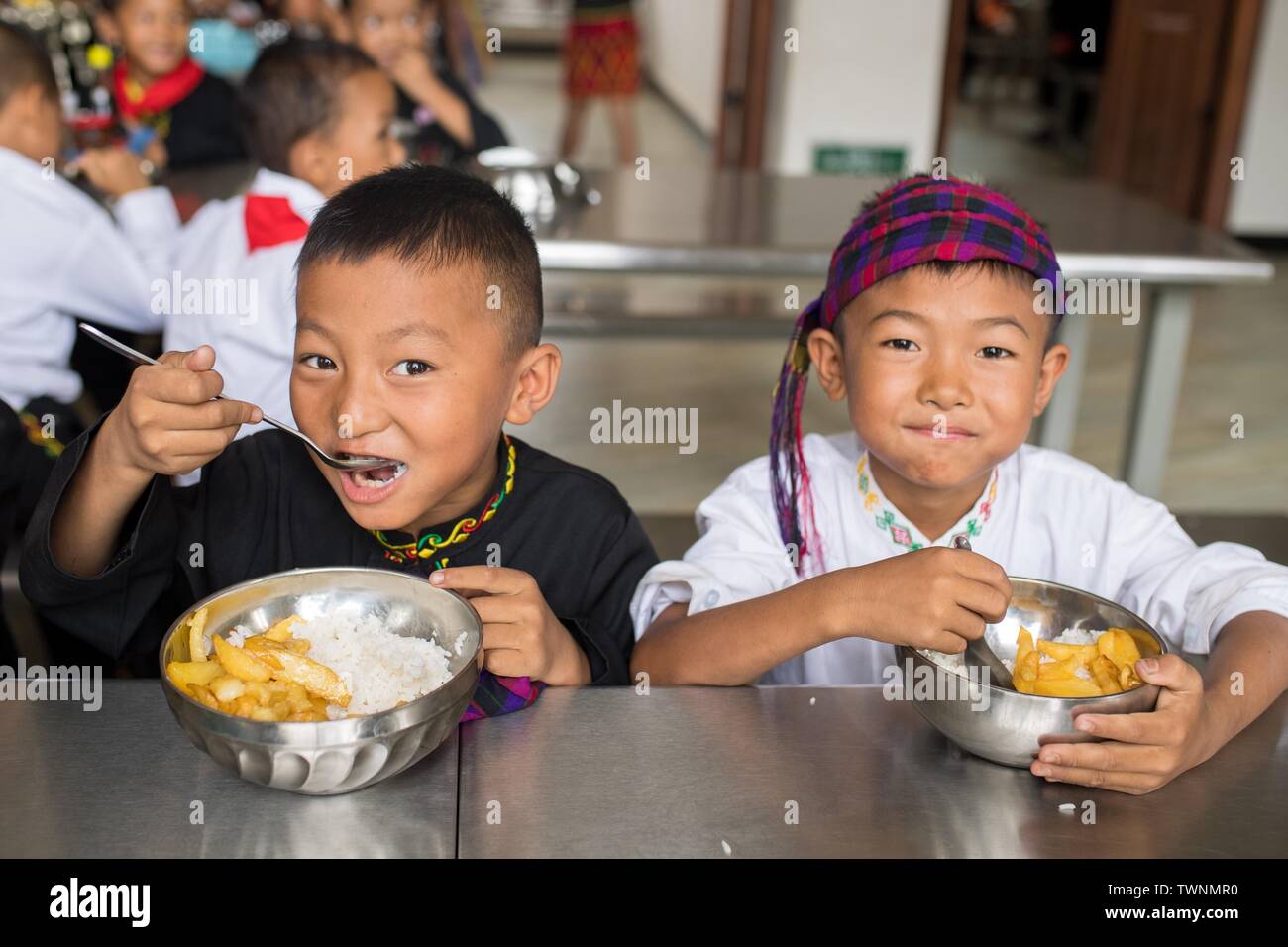 (190622) -- KUNMING, Giugno 22, 2019 (Xinhua) -- Gli allievi hanno il pranzo a Yingpan etnica scuola primaria in Xishan township di Città Mangshi, Dehong dai, e Jingpo prefettura autonoma, a sud-ovest della Cina di Provincia di Yunnan, 21 giugno 2019. Fondata nel 1958, la Yingpan etnica Scuola Primaria dispone di educazione bilingue con mandarin e Jingpo lingua etnica, come 314 dei 369 alunni qui sono di Jingpo gruppo etnico. Un bello e piacevole ambiente di apprendimento è ben fornita per i bambini di diversi gruppi etnici presso la scuola di ereditare le loro culture. (Xinhua/Hu Chao) Foto Stock