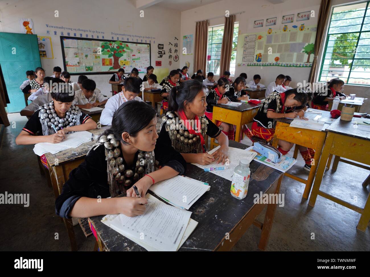 (190622) -- KUNMING, Giugno 22, 2019 (Xinhua) -- Alunni prendere lezioni a Yingpan etnica scuola primaria in Xishan township di Città Mangshi, Dehong dai, e Jingpo prefettura autonoma, a sud-ovest della Cina di Provincia di Yunnan, 21 giugno 2019. Fondata nel 1958, la Yingpan etnica Scuola Primaria dispone di educazione bilingue con mandarin e Jingpo lingua etnica, come 314 dei 369 alunni qui sono di Jingpo gruppo etnico. Un bello e piacevole ambiente di apprendimento è ben fornita per i bambini di diversi gruppi etnici presso la scuola di ereditare le loro culture. (Xinhua/Qin Qing) Foto Stock