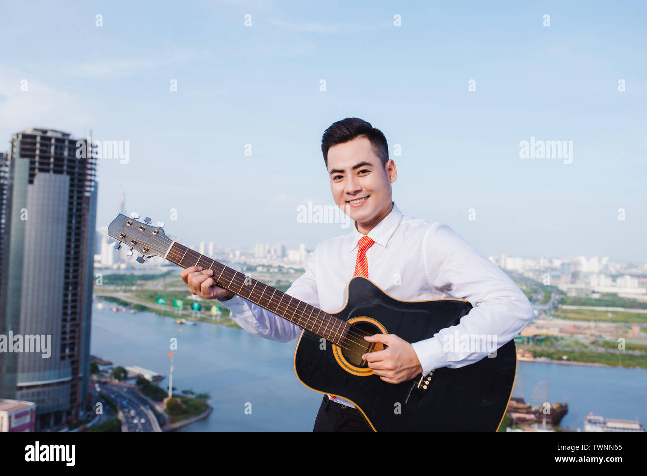 Concetto musicale. Uomo informale la riproduzione di praticare la chitarra. Foto Stock