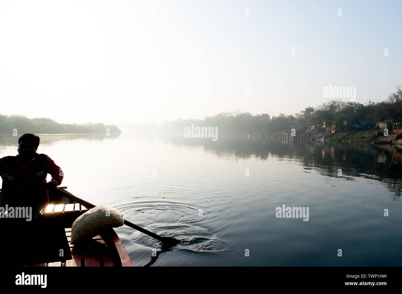 Silhouette di boatsman remare nella yamuna ganga river al mattino. La mattina presto giri in barca sul santo fiumi sacri dell India sono un comune Foto Stock