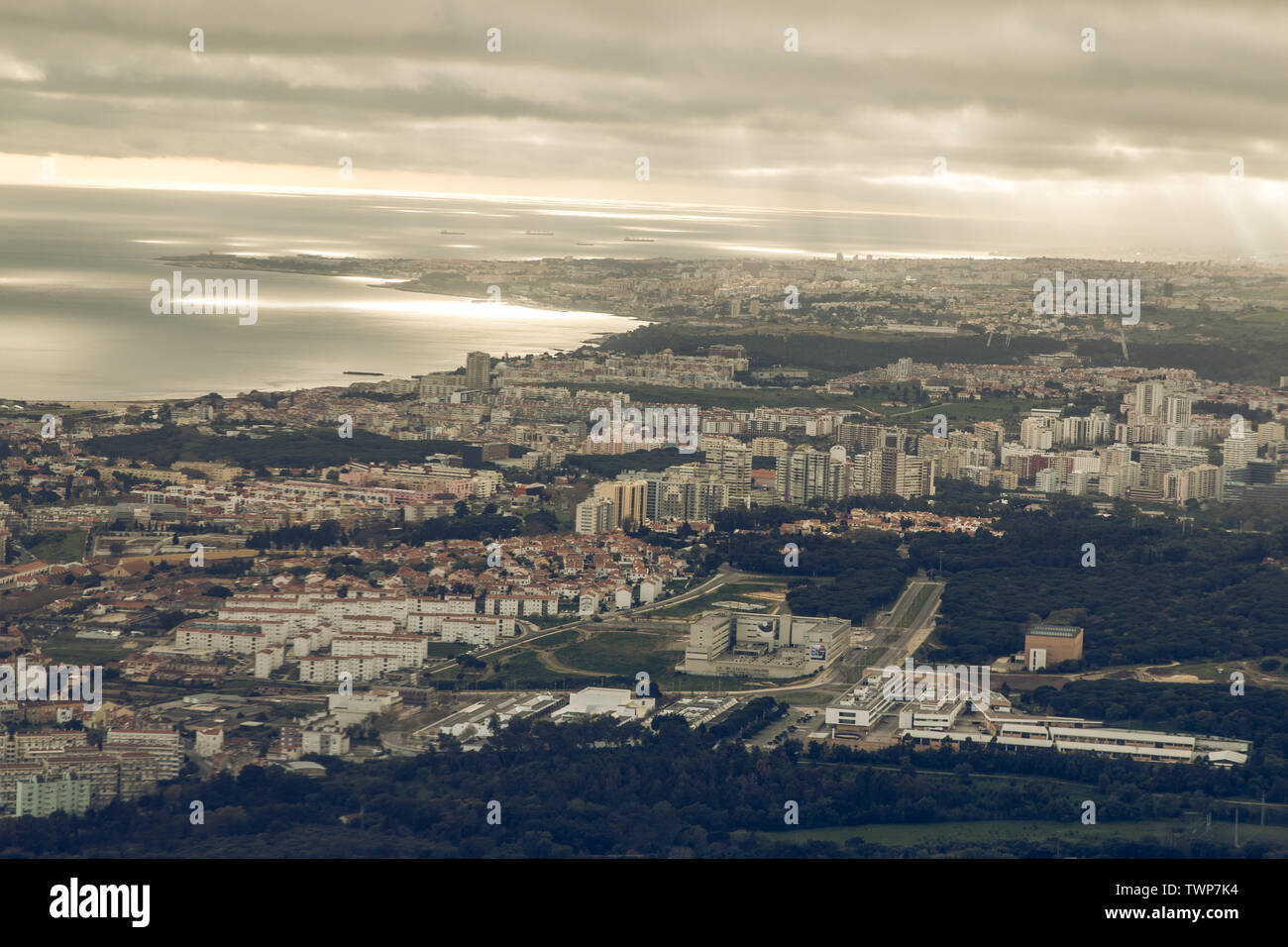 Capitale portoghese Lisbona da sopra. Skyline della città con le nuvole nel cielo. Edifici e la foce del fiume Tejo nome con il paesaggio e le navi sul Foto Stock