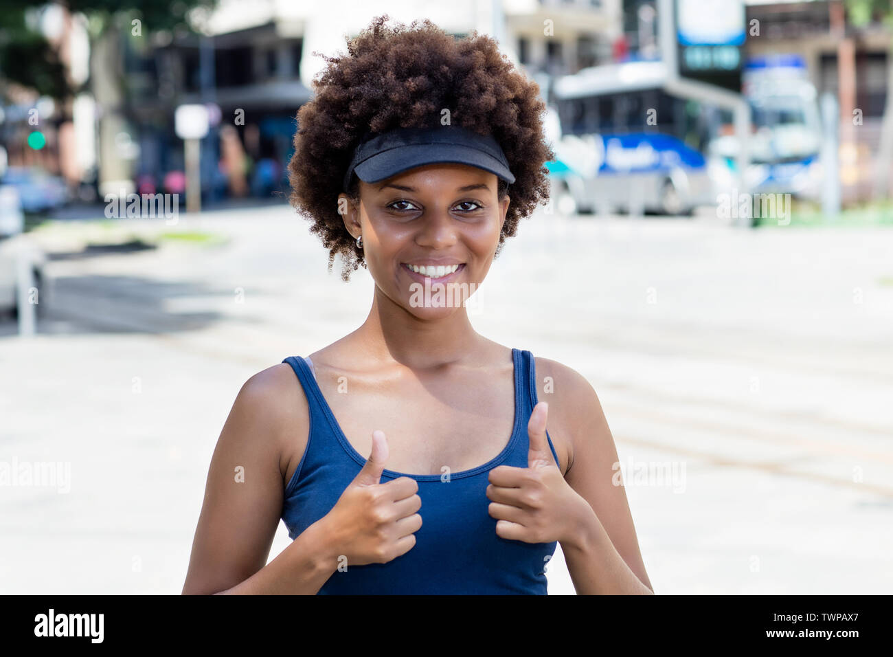 Sportivo americano africano giovane donna adulta all'aperto in città in estate Foto Stock