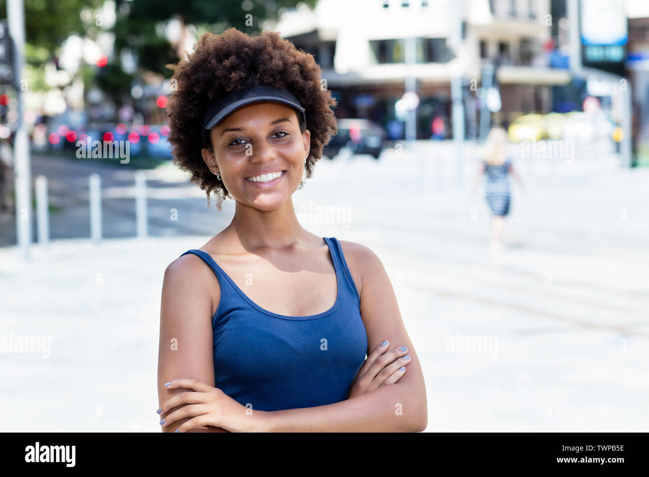 Ridendo americano africano giovane donna adulta all'aperto in città in estate Foto Stock
