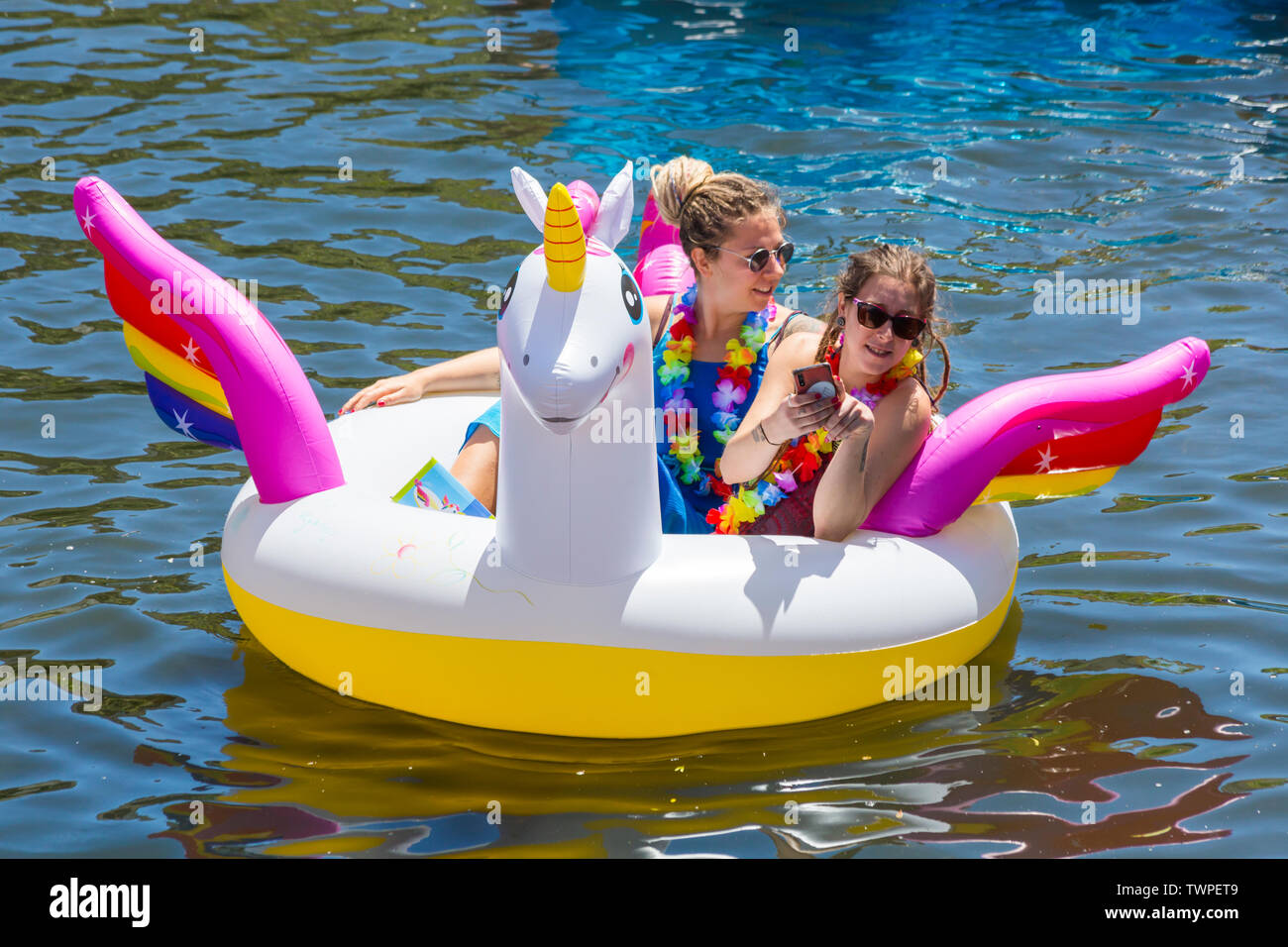 Iford, Dorset, Regno Unito. Il 22 giugno 2019. Il tempo era perfetto, caldo e soleggiato, ancora per Dorset Dinghy giorno con centinaia di gommoni, canotti pneumatici, artigianato, tavole che formano una flottiglia di salpare da ponte Iford giù il fiume Stour a ponte Tuckton. L'evento iniziato nel 2014 come un po' di divertimento, ma ora è diventato un evento annuale la raccolta di fondi per la carità ed il getter più grande di ogni anno. Le donne che si divertono sull'unicorno gonfiabile gonfiabile. Credito: Carolyn Jenkins/Alamy Live News Foto Stock