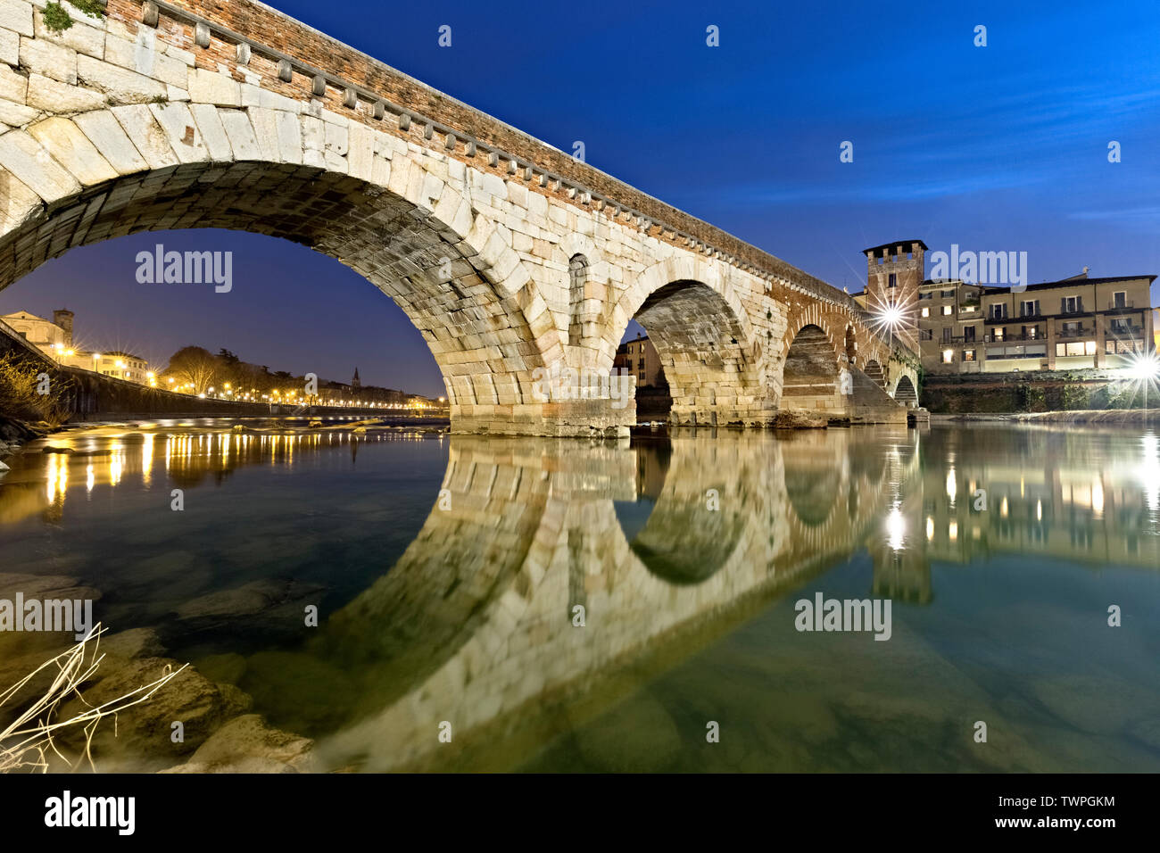 Gli archi del Ponte di Pietra sono riflessi nel fiume Adige. Verona, Veneto, Italia, Europa. Foto Stock