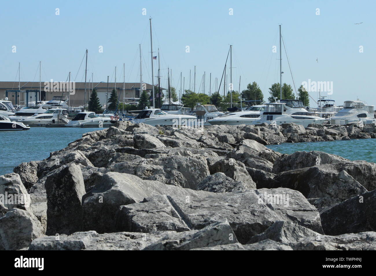 Montaggio di macerie frangionde con barche ormeggiate all'interno di Southeastern Wisconsin, USA...in una giornata di sole nel giugno 2019. Foto Stock