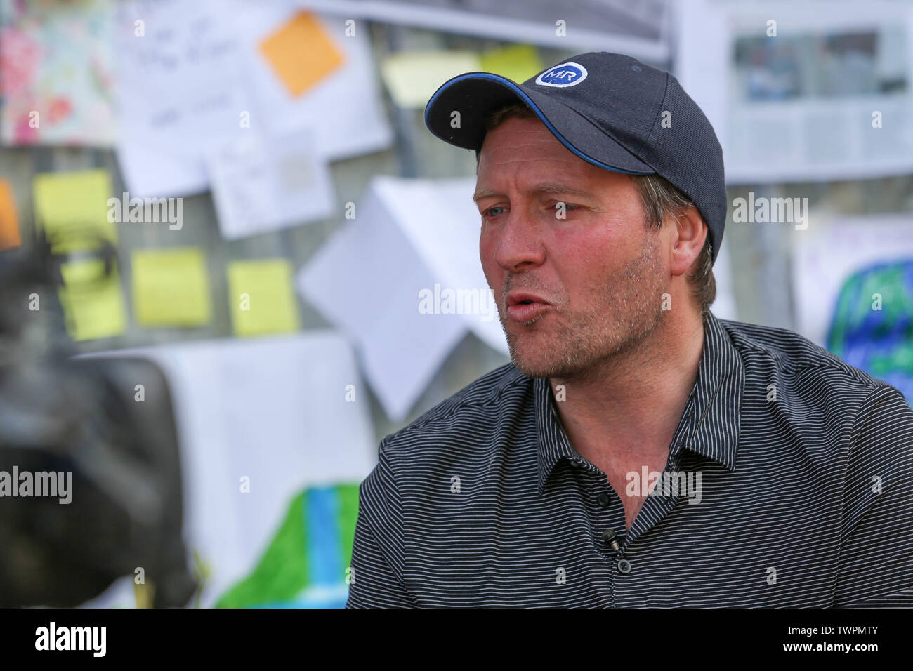Ambasciata iraniana, Londra, Regno Unito. 22 giugno 2019. Richard Ratcliffe che indossa un cappellino da baseball scuro e una polo a righe viene intervistato o filmato di fronte a una parete coperta da note scritte a mano, documenti stampati e illustrazioni colorate. Richard Ratcliffe continua lo sciopero della fame fuori dall'ambasciata iraniana a Knightsbridge. Richard è il marito di Nazanin Zaghari-Ratcliffe, imprigionato in Iran. Penelope Barritt/Alamy Live News Foto Stock
