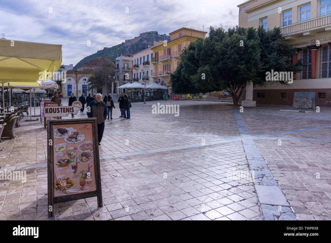 Nafplio, Peloponneso / Grecia - 5 Febbraio 2017: vista pittoresca della centrale piazza pavimentata con vecchie case tradizionali, edifici, caffetterie, restaura Foto Stock
