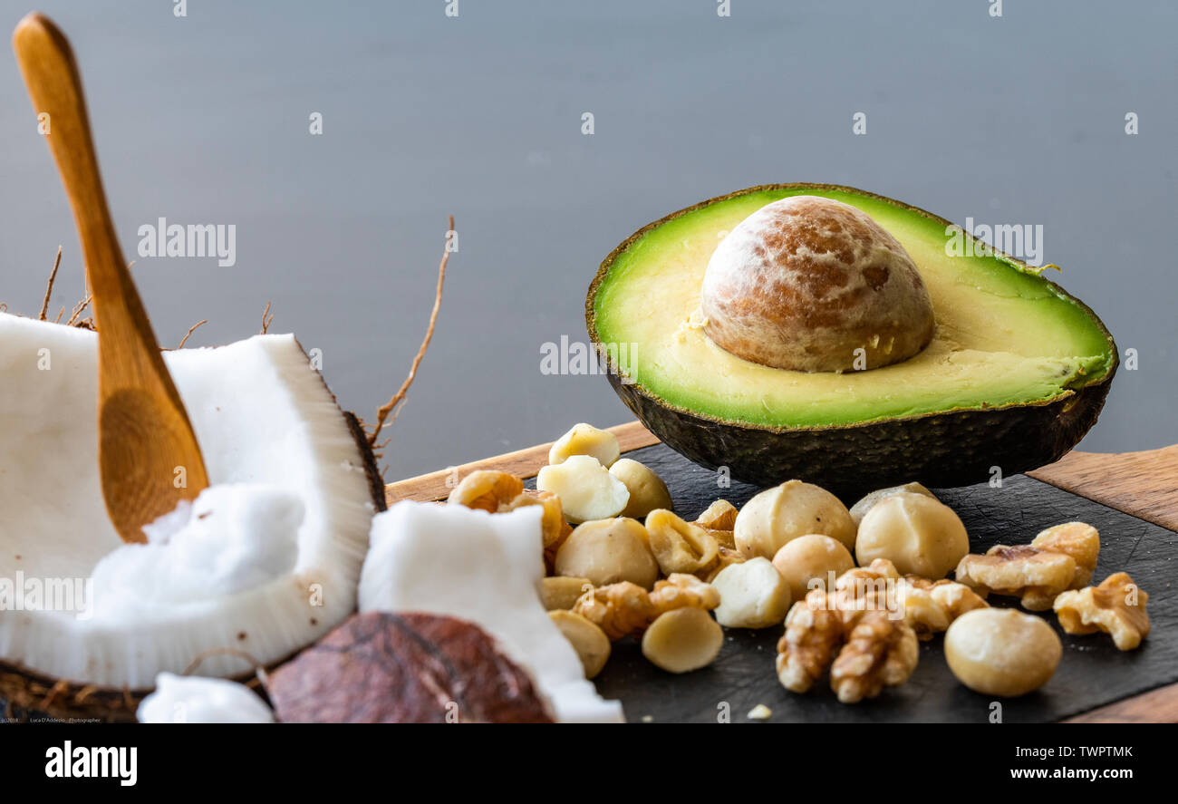 Una chiusura del cibo ketogenic: noce di cocco e il burro di noce di cocco, avocado, noci e noci di macadamia Foto Stock