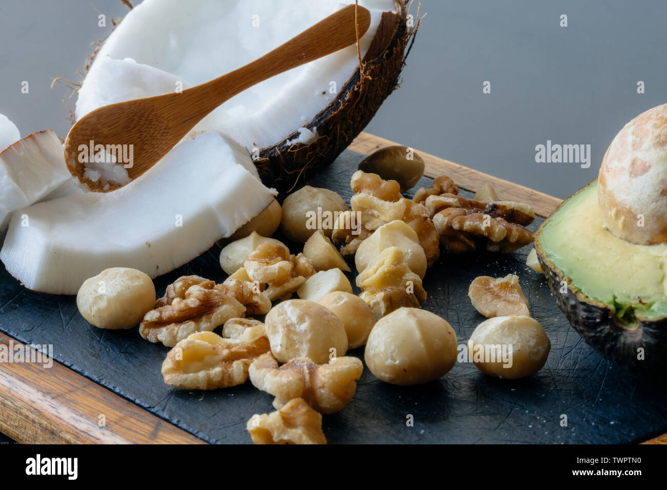 Una chiusura del cibo ketogenic: noce di cocco e il burro di noce di cocco, avocado, noci e noci di macadamia Foto Stock