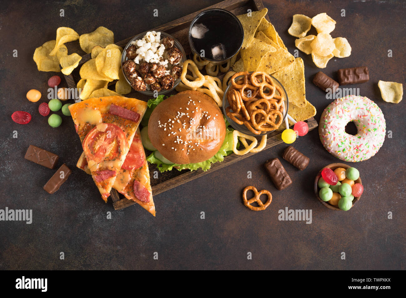 Assortimento di cibo malsano, vista dall'alto, copia dello spazio. Mangiare malsano, junk food concept. Foto Stock