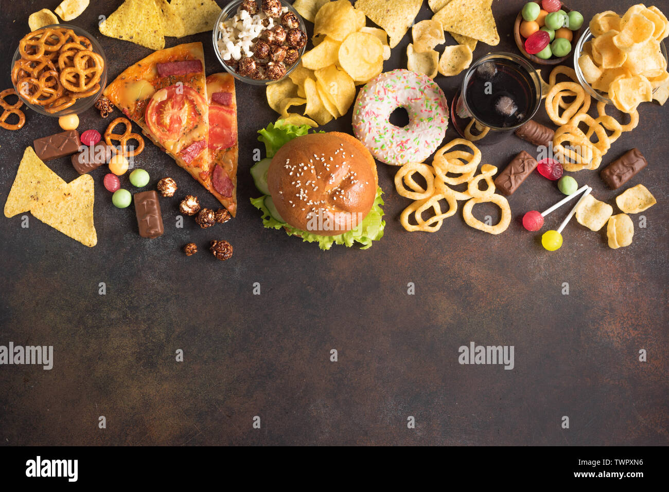 Assortimento di cibo malsano, vista dall'alto, copia dello spazio. Mangiare malsano, junk food concept. Foto Stock